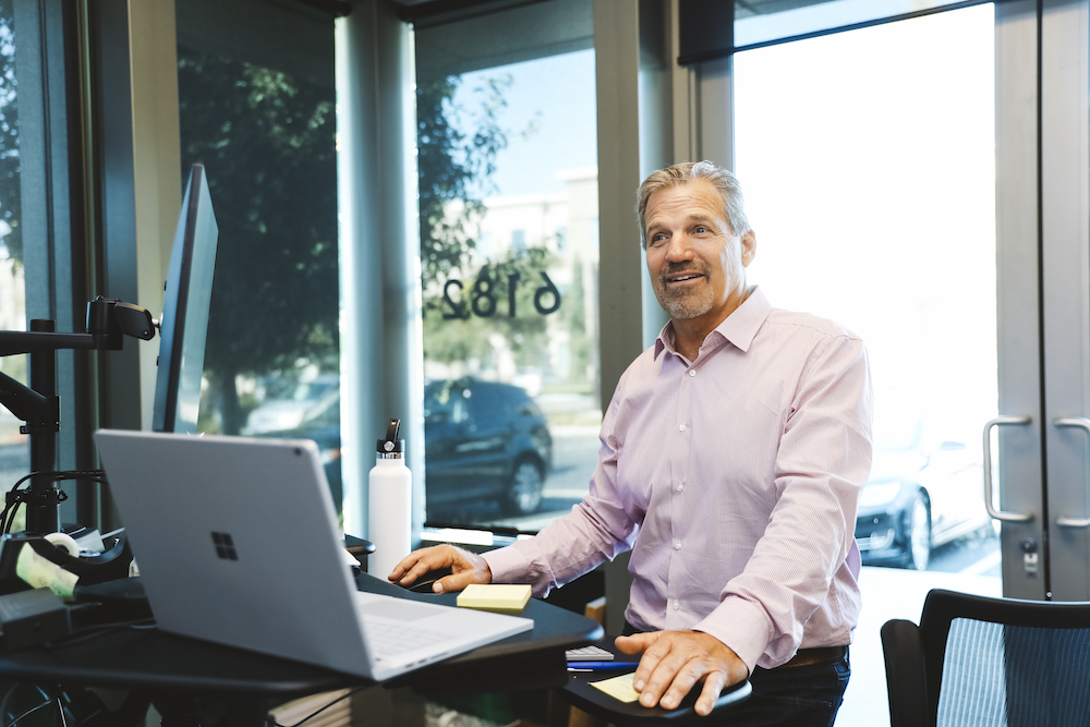 Frank Naliboff, CEO of Dickinson Cameron, stands at his office desk. 